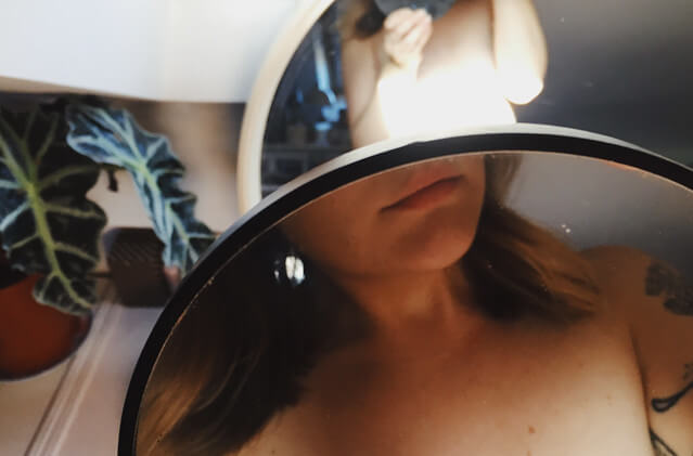 Lyzi's mouth and shoulders reflected in two circular mirrors