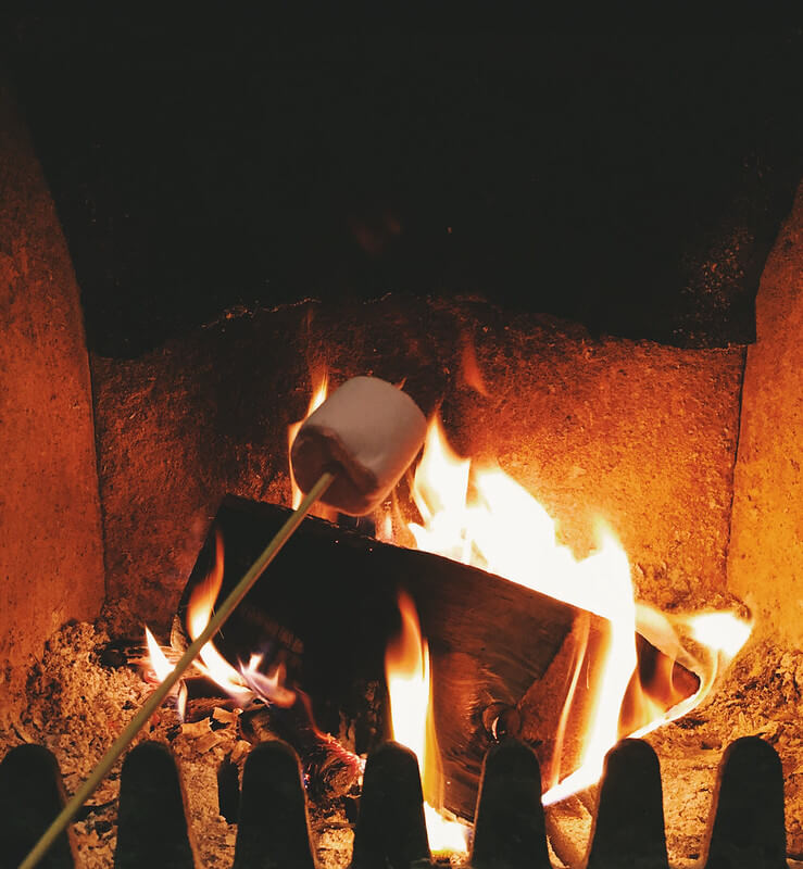 Toasting marshmallows at Log House Holidays lakeside cabin retreat in the Cotswolds