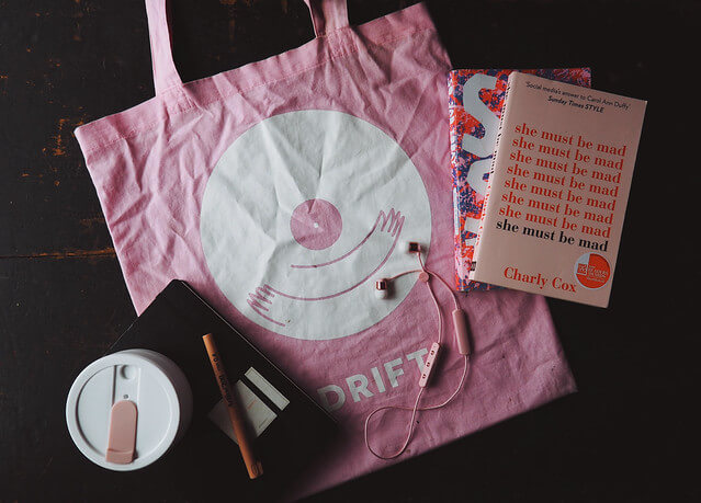 Pink record store tote bag with Sudio headphones and other travel essentials