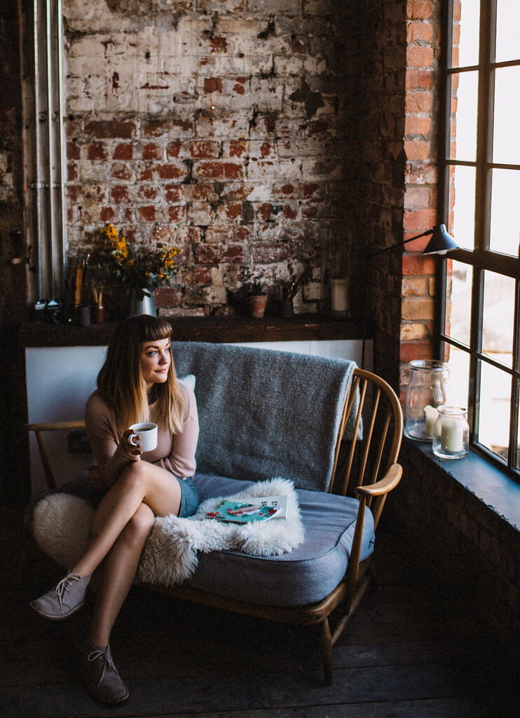 Lyzi Unwin drinking tea and trying to get motivated on Ercol sofa at The Forge Bristol, by Lauren Jayne Hall