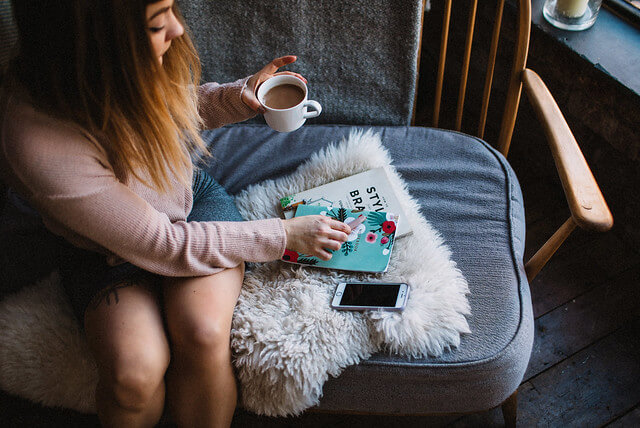 Lyzi Unwin drinking tea on Ercol sofa at The Forge Bristol, by Lauren Jayne Hall