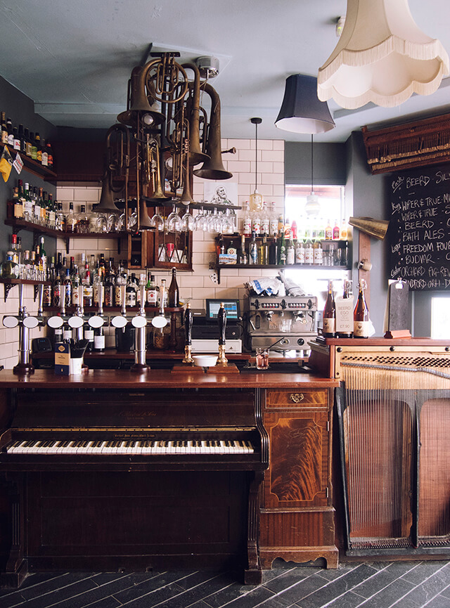 Bar area in the Old Bookshop pub, Bristol, with piano bar and trumpet light fixture