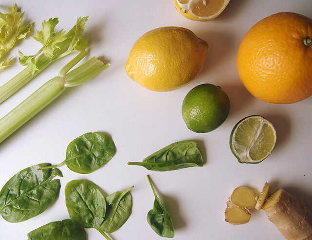 colourful flatlay of lemons, limes, spinach and ginger