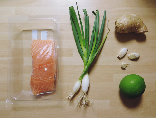 Ingredients laid out: salmon, spring onions, ginger, garlic and lime