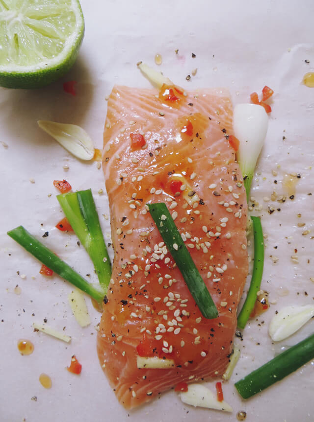 salmon on greaseproof paper with cut lime and spring onion