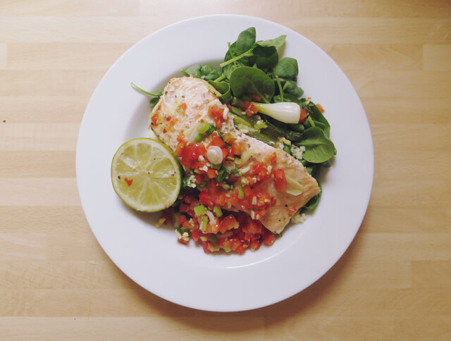 Baked salmon with salad and cut lime