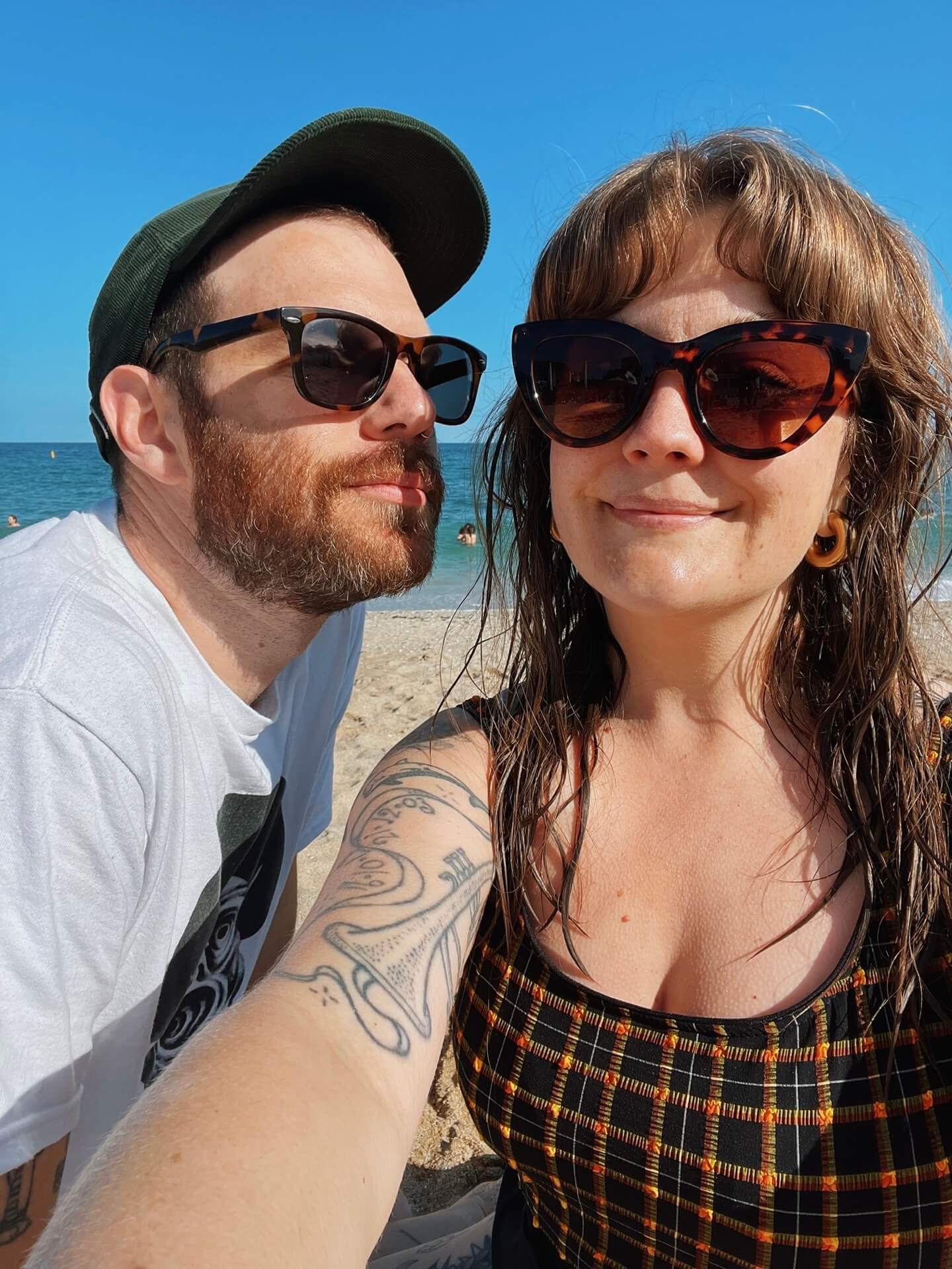 Two happy people with sunglasses on take a selfie at Gylly beach