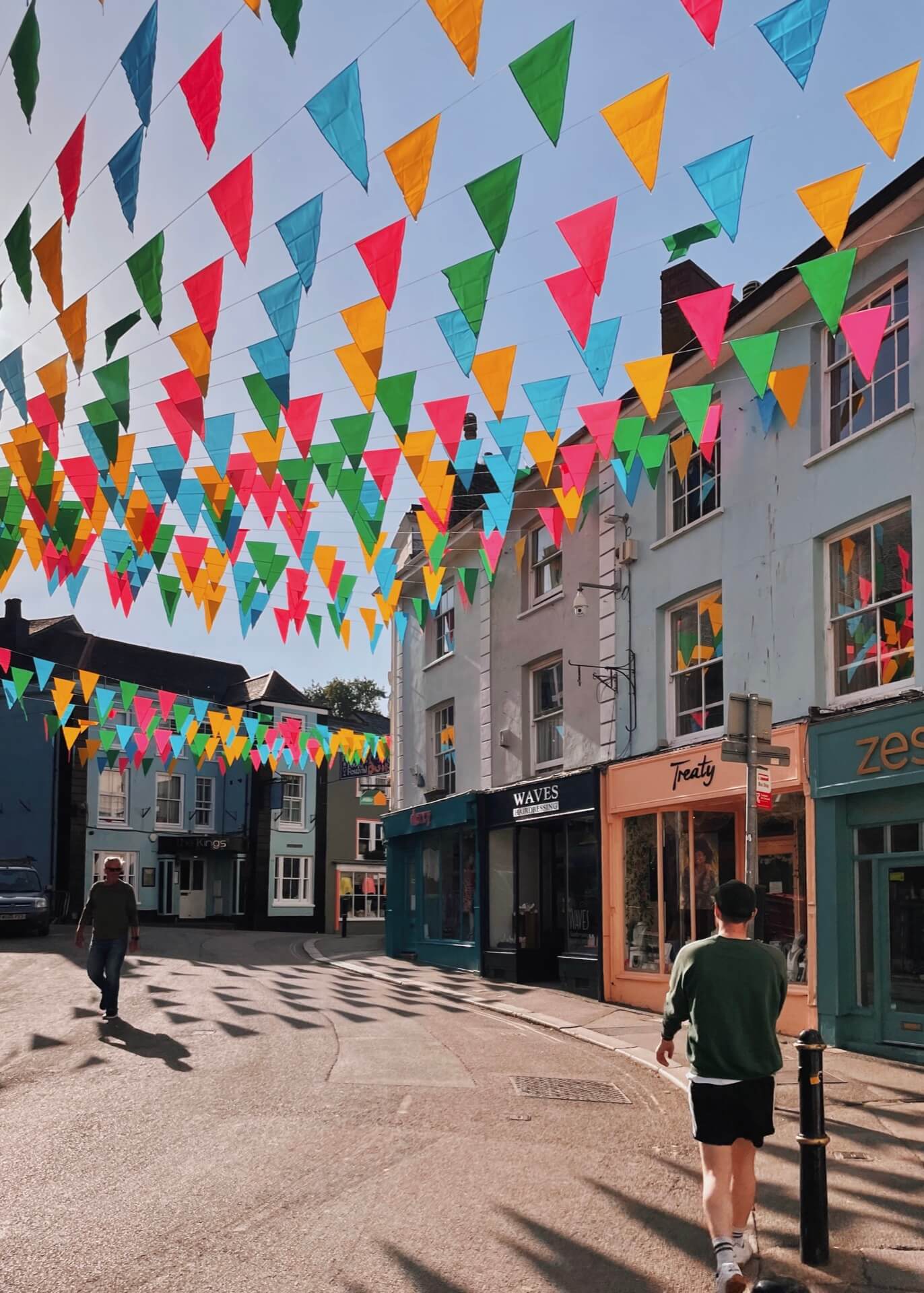 Colourful flags and shops on Falmouth high street