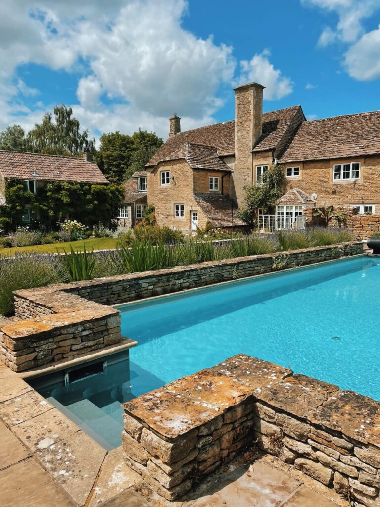The swimming pool and main farmhouse at Church Farm Estate