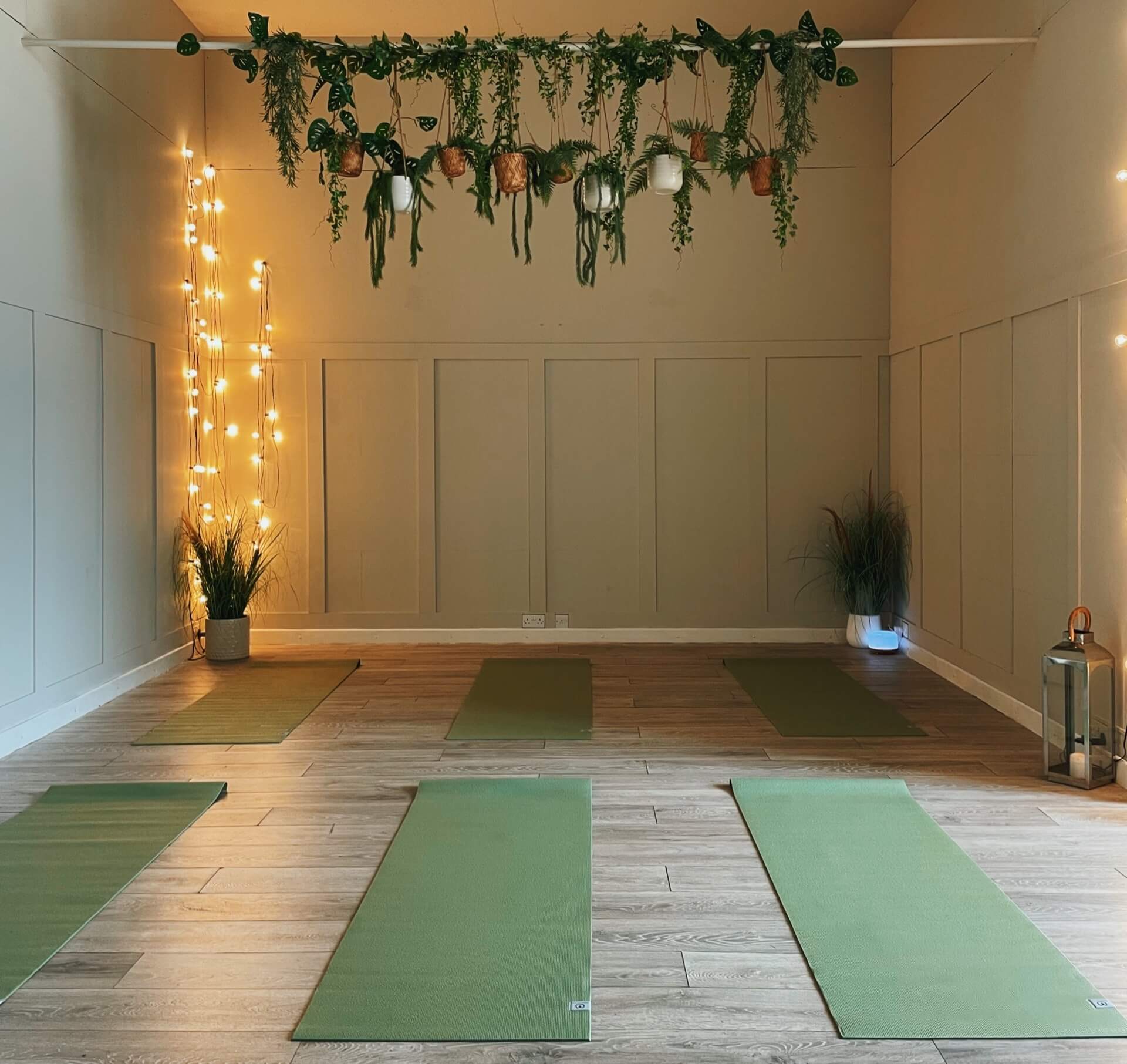 The barn at Church Farm Estate set up for yoga with mats and fairy lights 