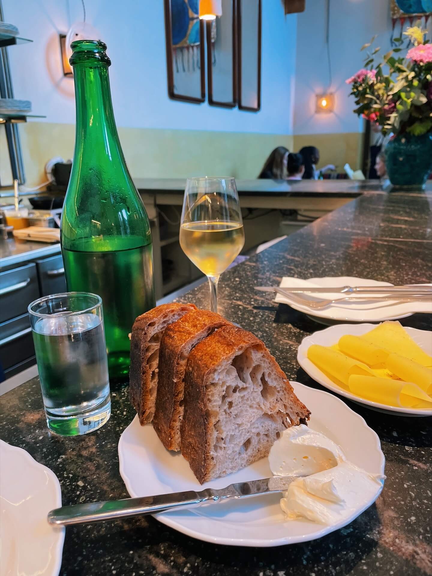 Water, wine, bread, butter and cheese at the bar at Apollo Copenhagen