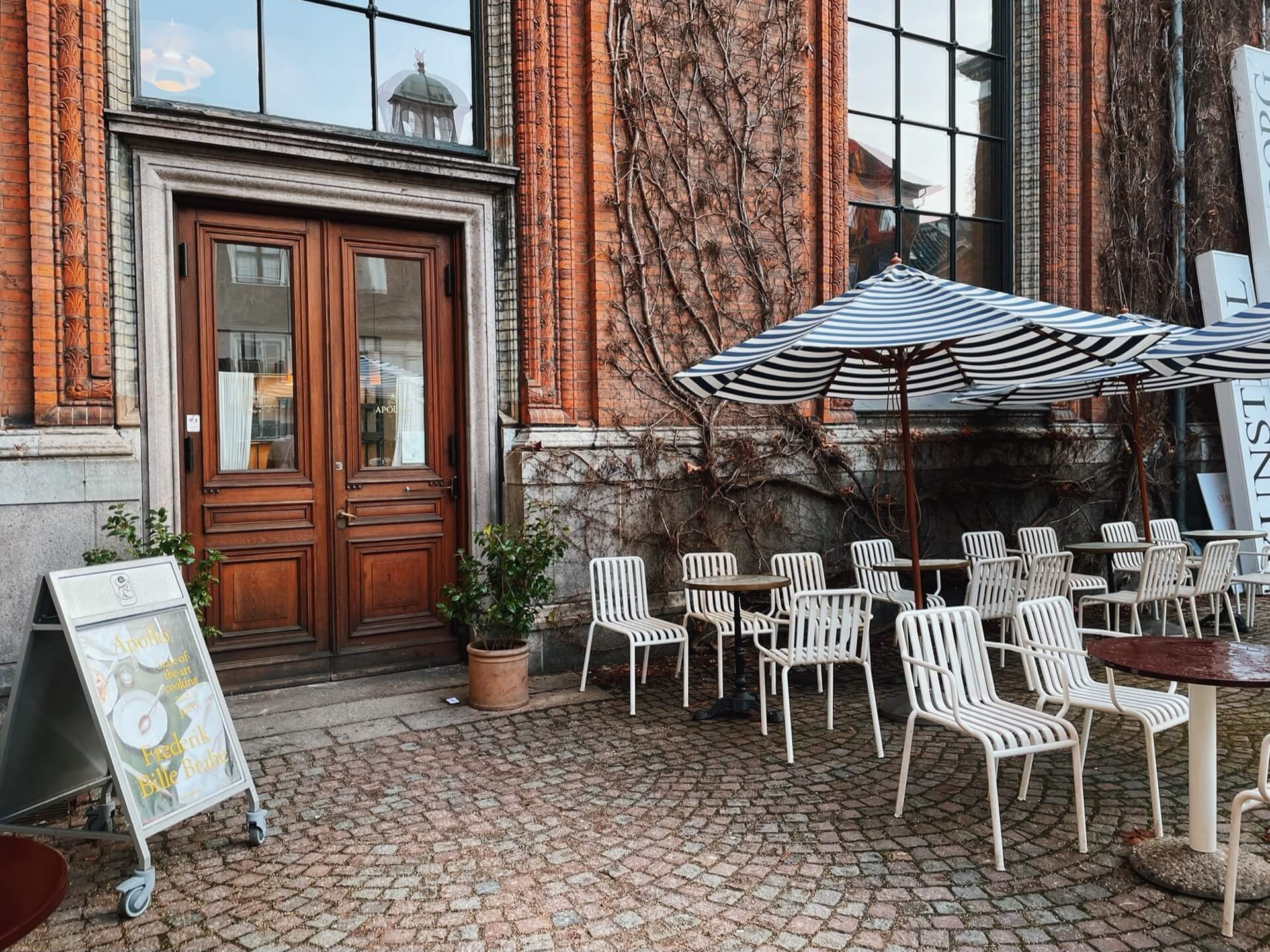 Outside Apollo Bar Copenhagen, with chairs and striped parasol