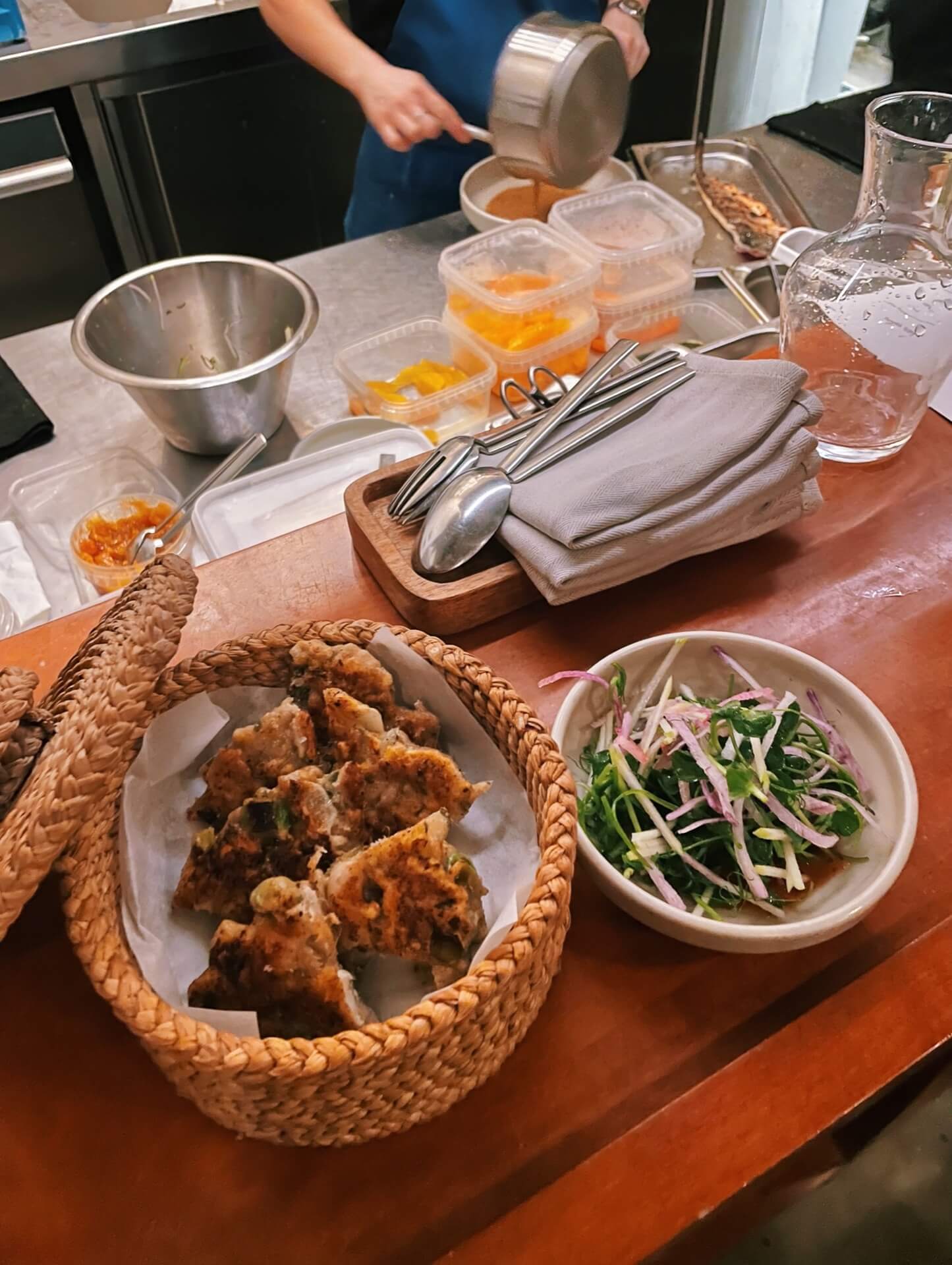 Chicken & scallion pancakes at the bar with chef in background at Bar Vitrine Copenhagen