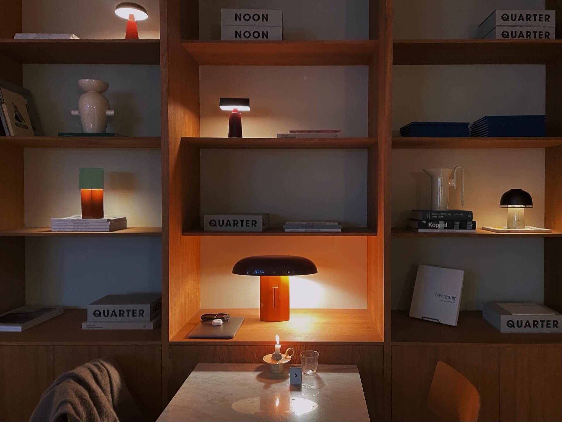 Beautiful wooden shelving with books and midcentury style lamps at Lille Petra in Copenhagen